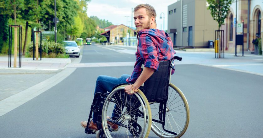 Disabled Man In Wheelchair On Road